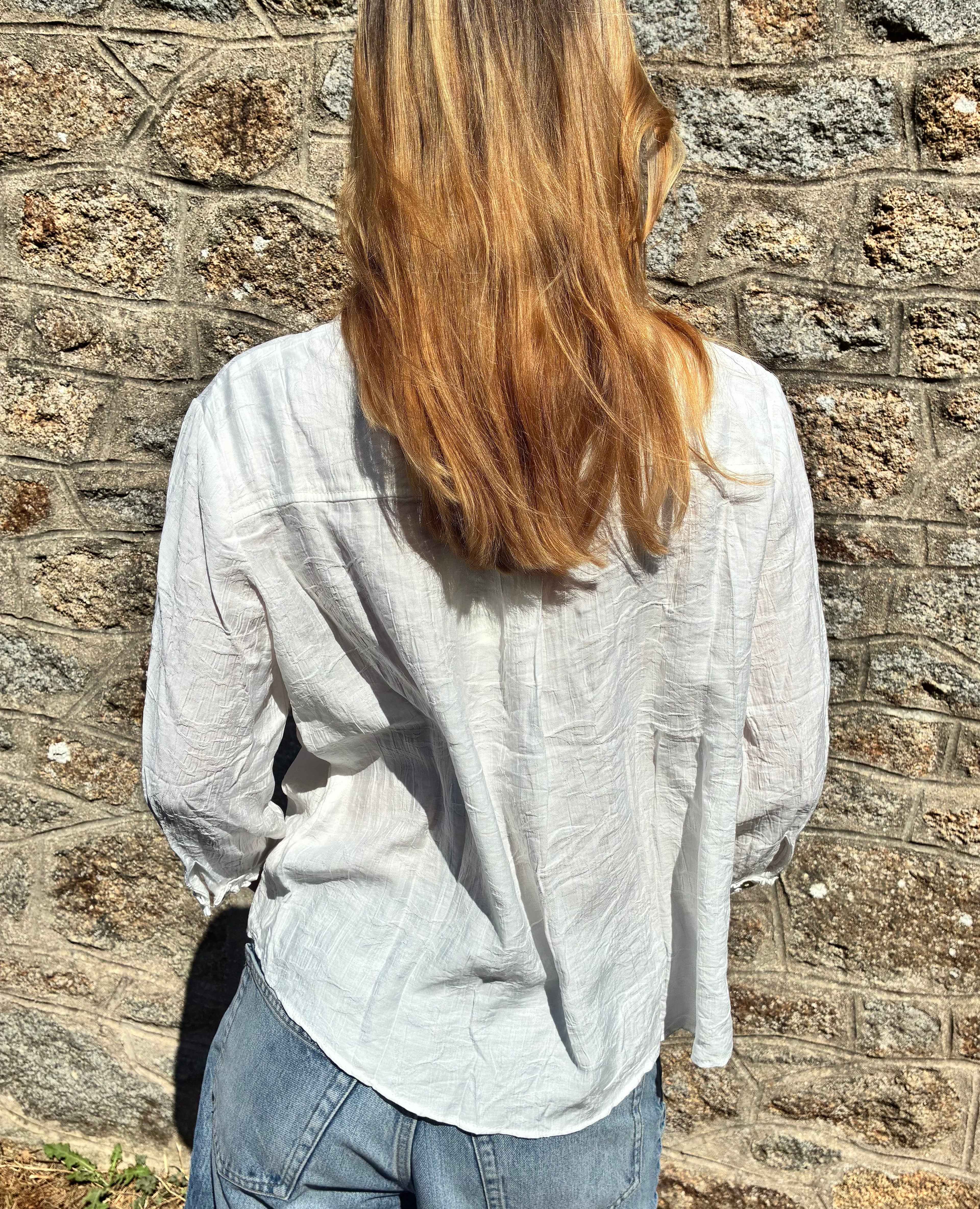 Blouse blanche élégante de la marque Le Vestiaire, en tissu léger, avec col et manches longues, vue de face.