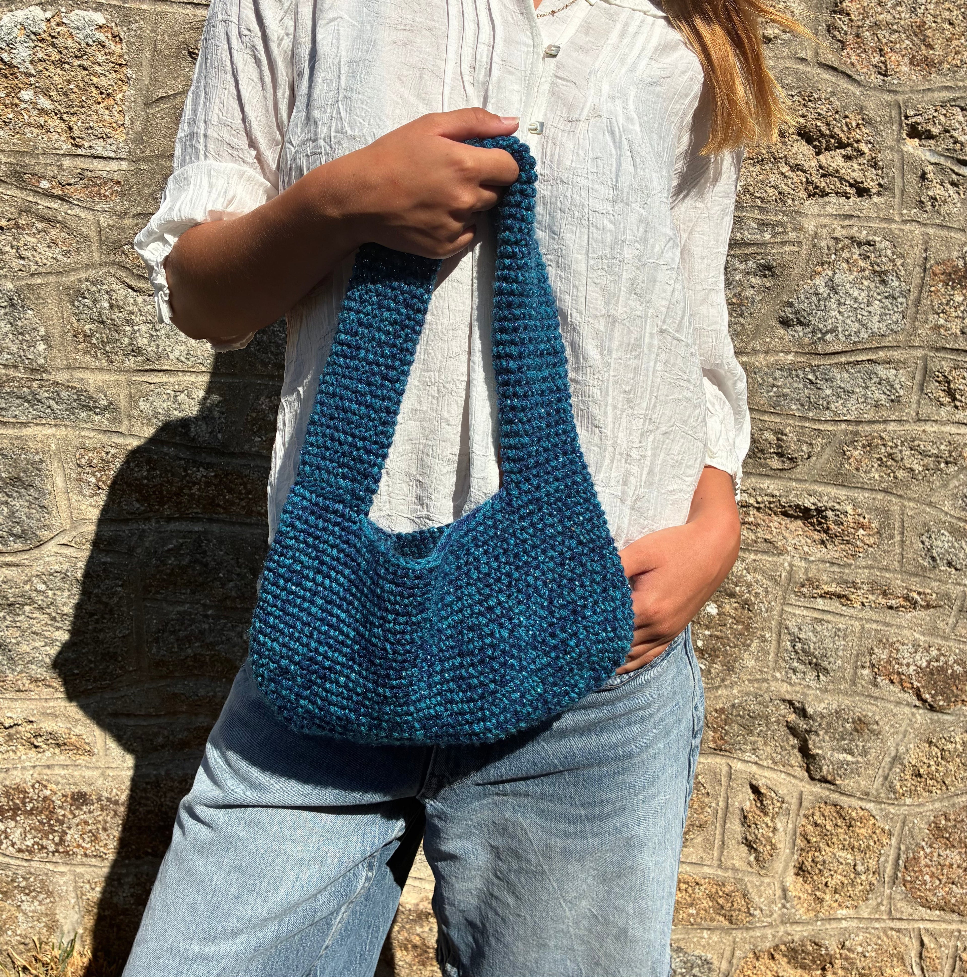 Sac BOB bleu de Le Vestiaire, sac à main en cuir avec bandoulière, visible devant avec détails en cuir et finition élégante.