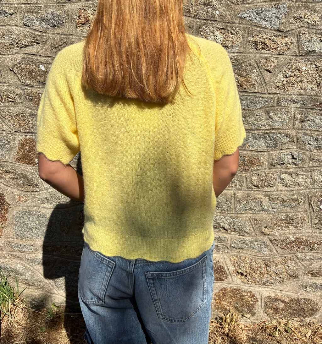 Pull jaune Le Vestiaire en laine avec col rond, porté sur mannequin, mettant en valeur la texture douce et la coupe élégante.
