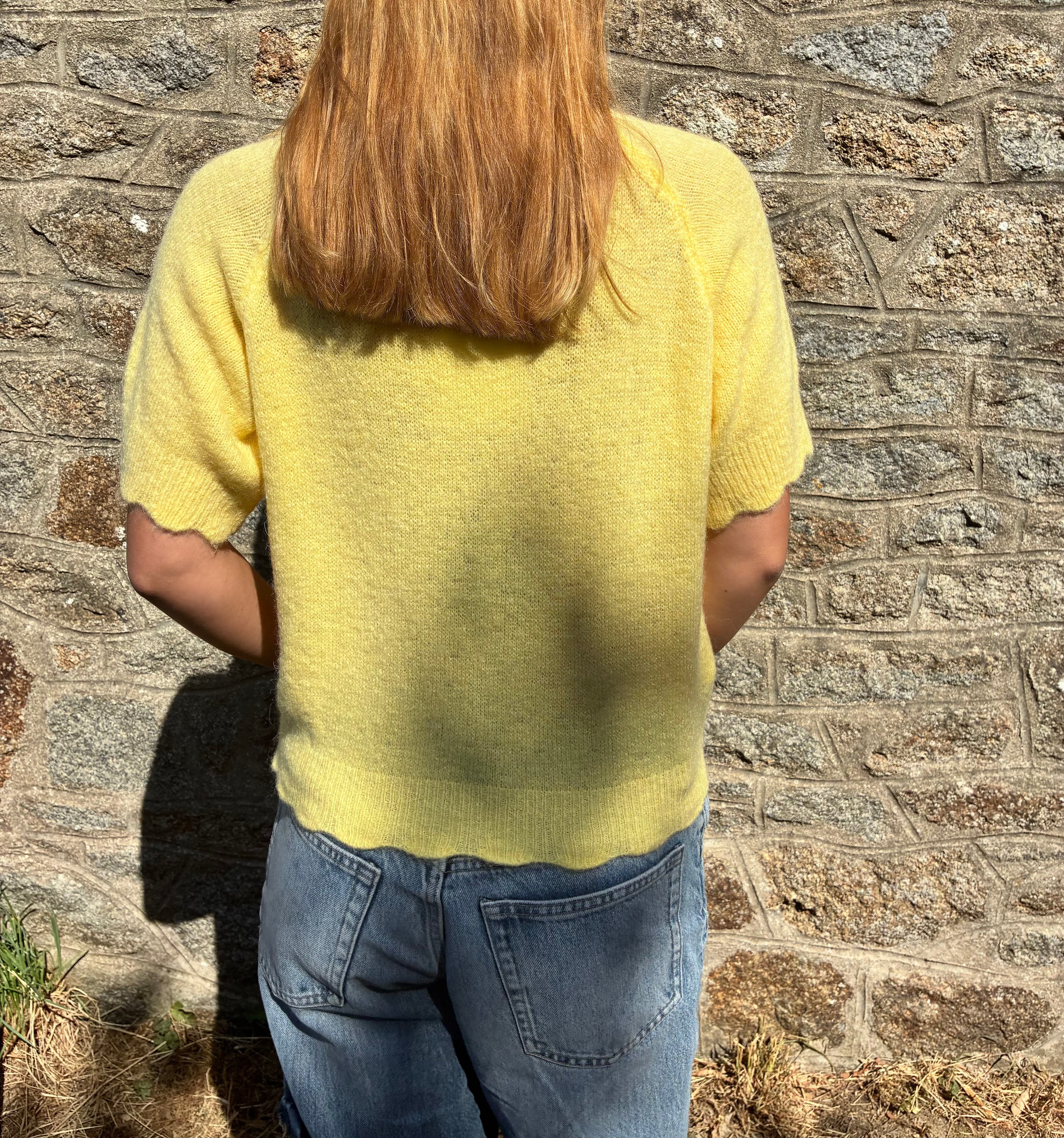 Pull jaune Le Vestiaire en laine avec col rond, porté sur mannequin, mettant en valeur la texture douce et la coupe élégante.